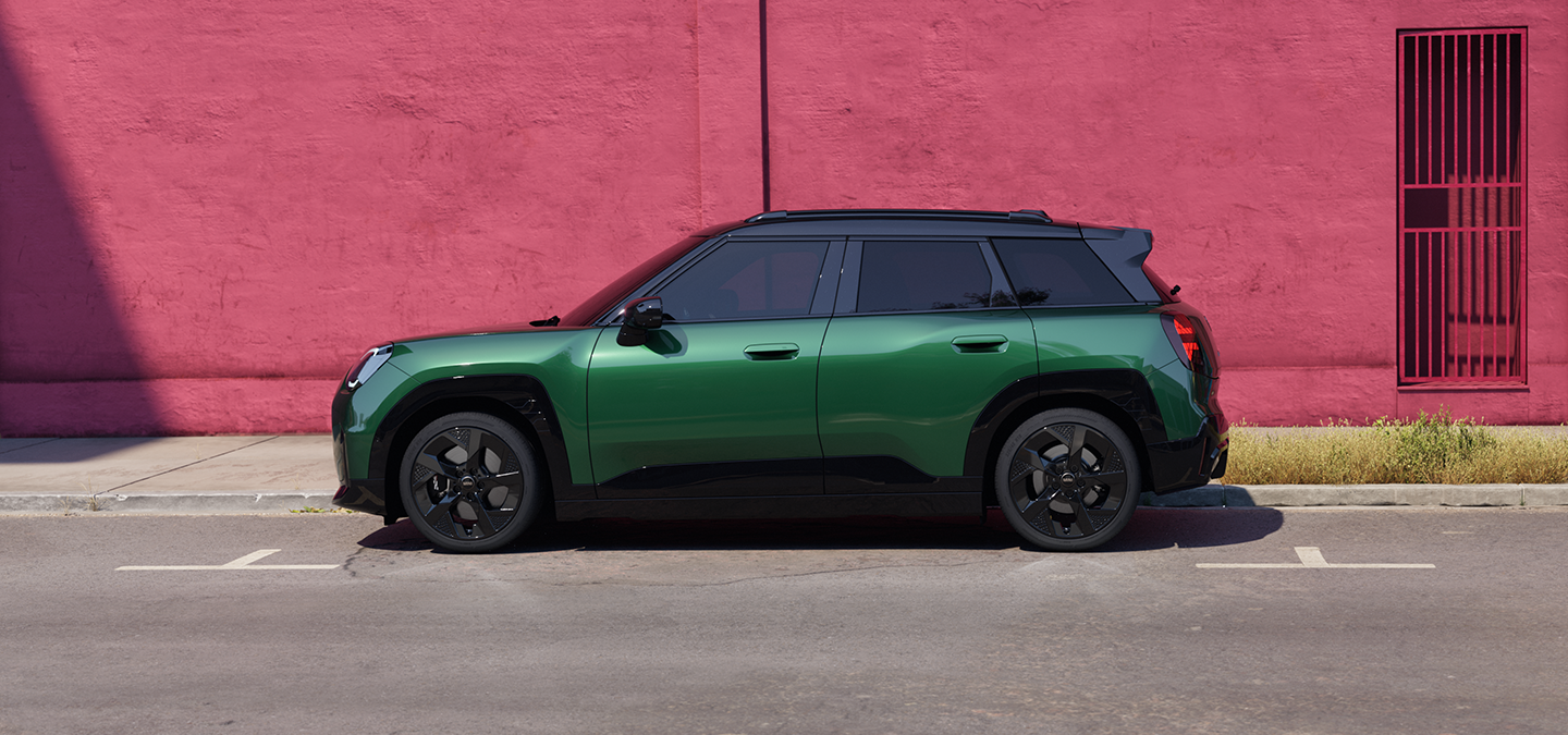 Вигляд збоку повністю електричного MINI Aceman кольору British Racing Green з чорним дахом.