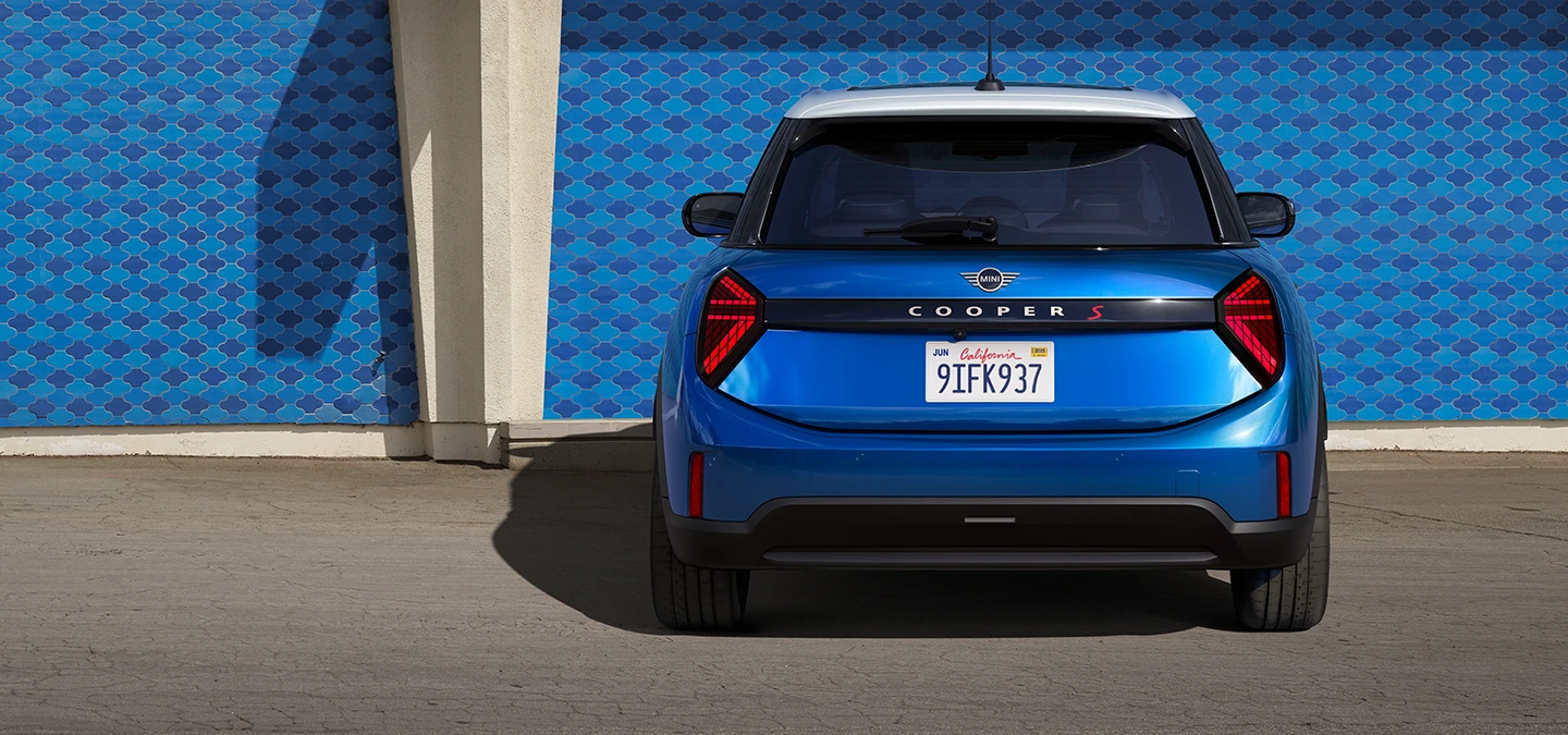 Вигляд ззаду 5-дверного MINI Cooper у кольорі Icy Sunshine Blue та Multitone Roof Blue.