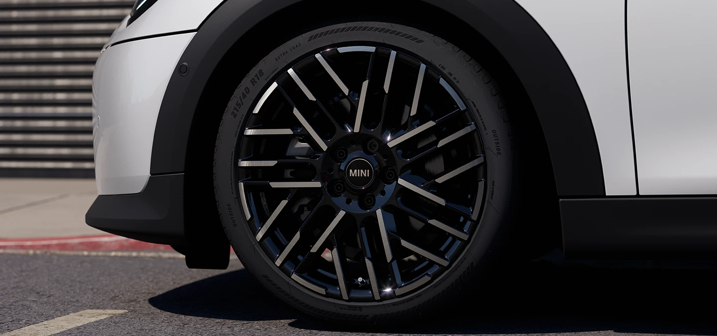 Крупний план 5-дверного MINI Cooper у кольорі Nanuq White з двоколірними дисками Night Flash Spoke.