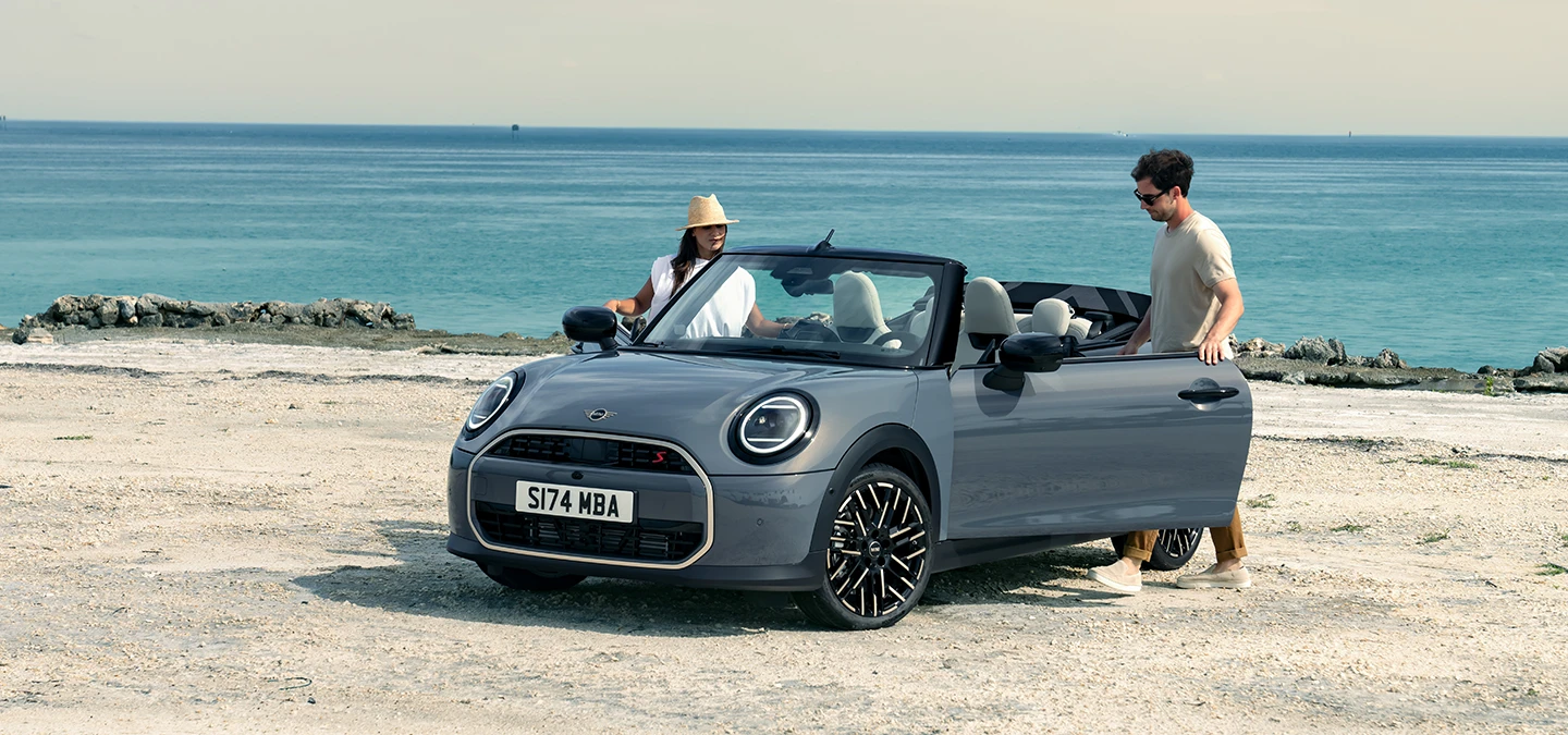 Вигляд MINI Cooper Convertible кольору Copper Grey спереду зліва.