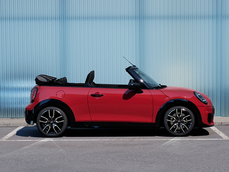 Вигляд збоку на MINI Cooper Convertible кольору Chili Red.