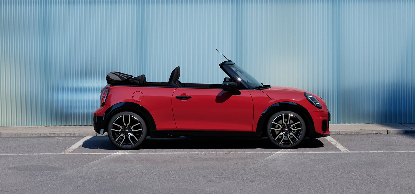 Вигляд збоку на MINI Cooper Convertible кольору Chili Red.