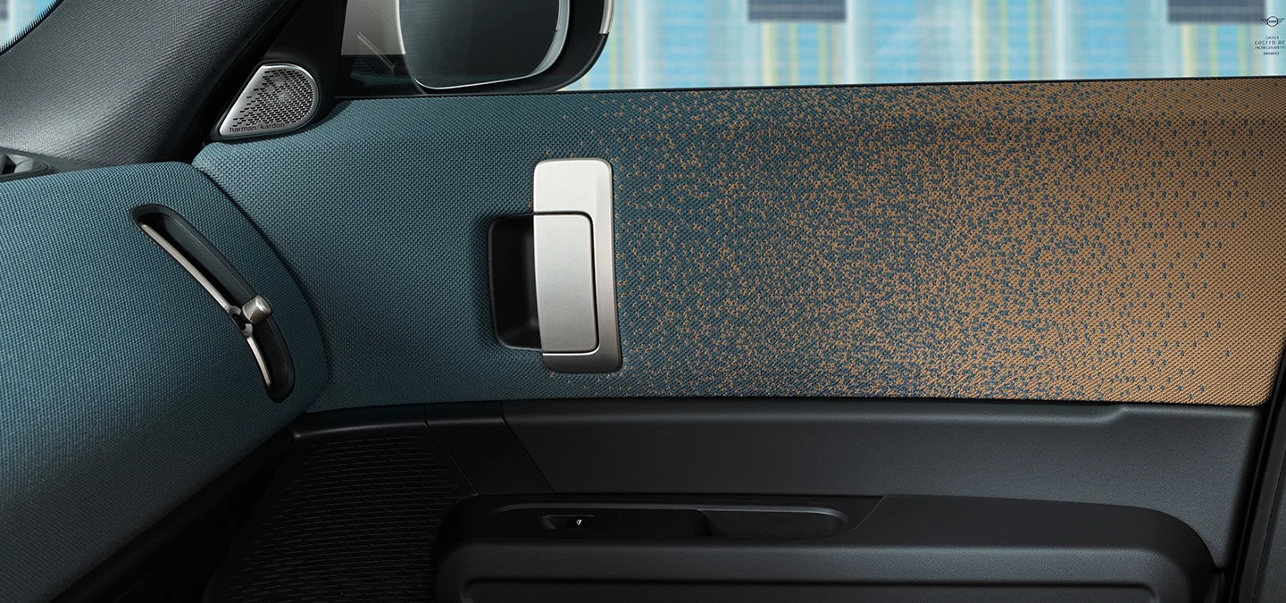 Детальний огляд дизайну інтер'єру повністю електричного MINI Countryman з акцентом на дверях і приладовій панелі.