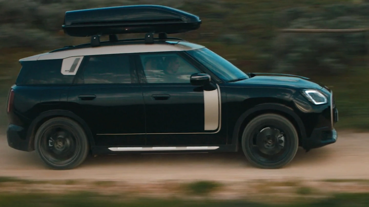 MINI Countryman у кольорі Midnight Black металік із 19-дюймовими дисками John Cooper Works Runway Spoke чорного кольору на бездоріжжі. 