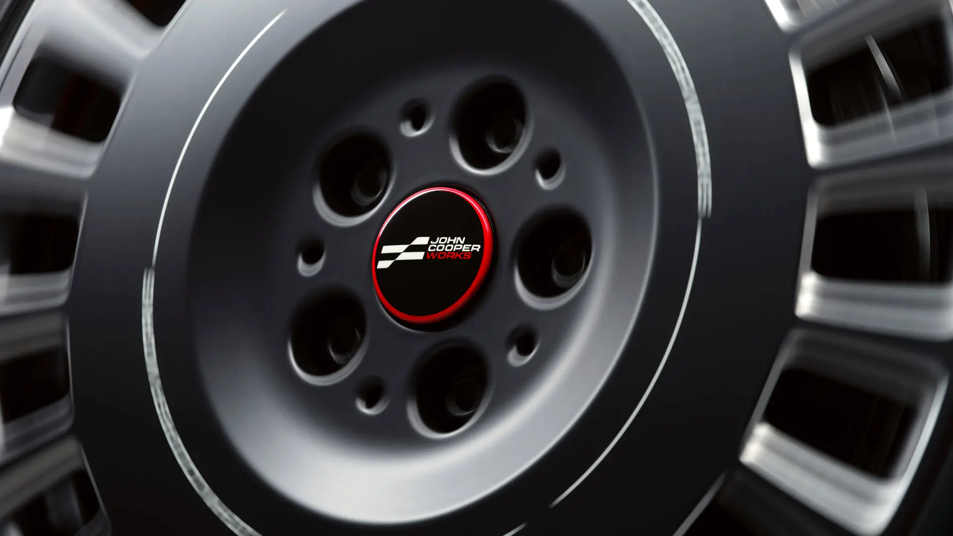 Крупний план центральної кришки колеса MINI JCW, яка зберігає горизонтальне положення під час обертання колеса.