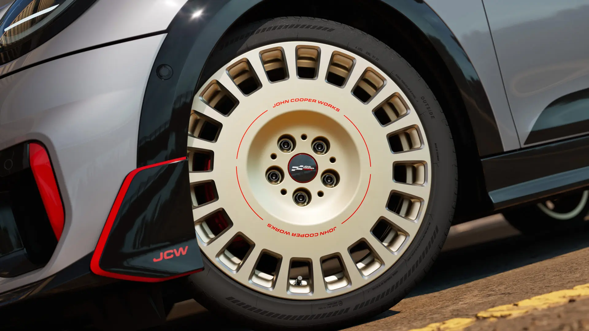 Крупний план деталей колеса JCW Rallye Spoke 964 діаметром 18 дюймів у двоколірному виконанні Vibrant Silver із алмазною обробкою та переднім крилоподібним елементом.