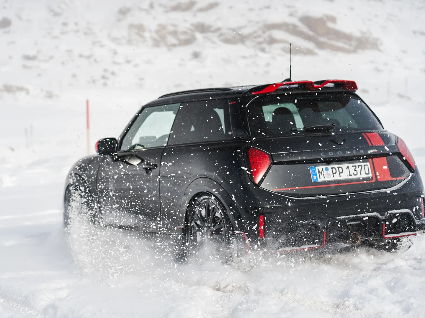 MINI Cooper JCW на засніженій дорозі, вид ззаду.