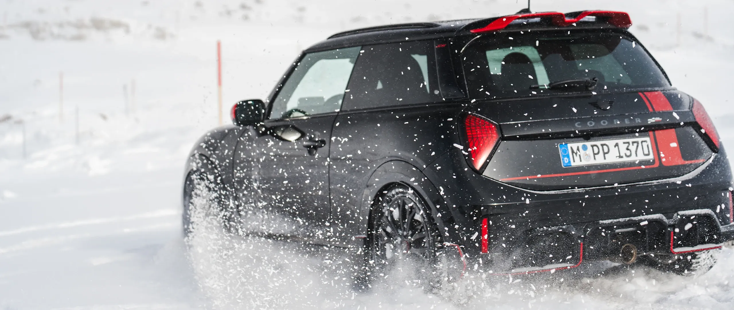 MINI Cooper JCW на засніженій дорозі, вид ззаду.