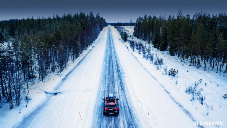 MINI Cooper з верхнім багажником на засніженій дорозі, вид ззаду.