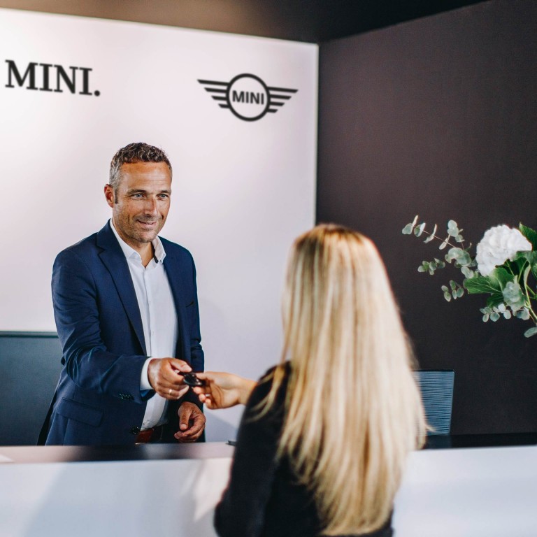 Аксесуари MINI – представник сервісного центру mini передає ключі від машини жінці